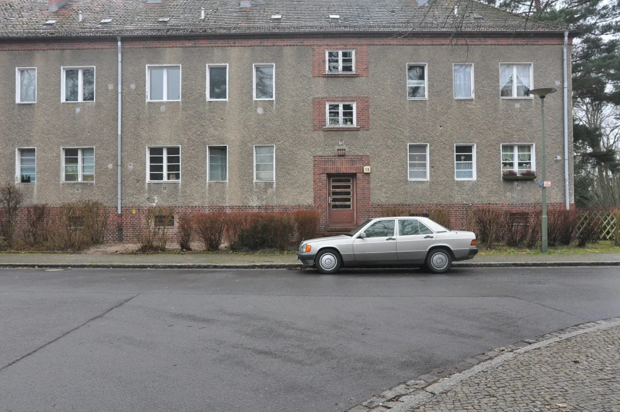 Ruhige Wohnfassade mit geparktem Auto