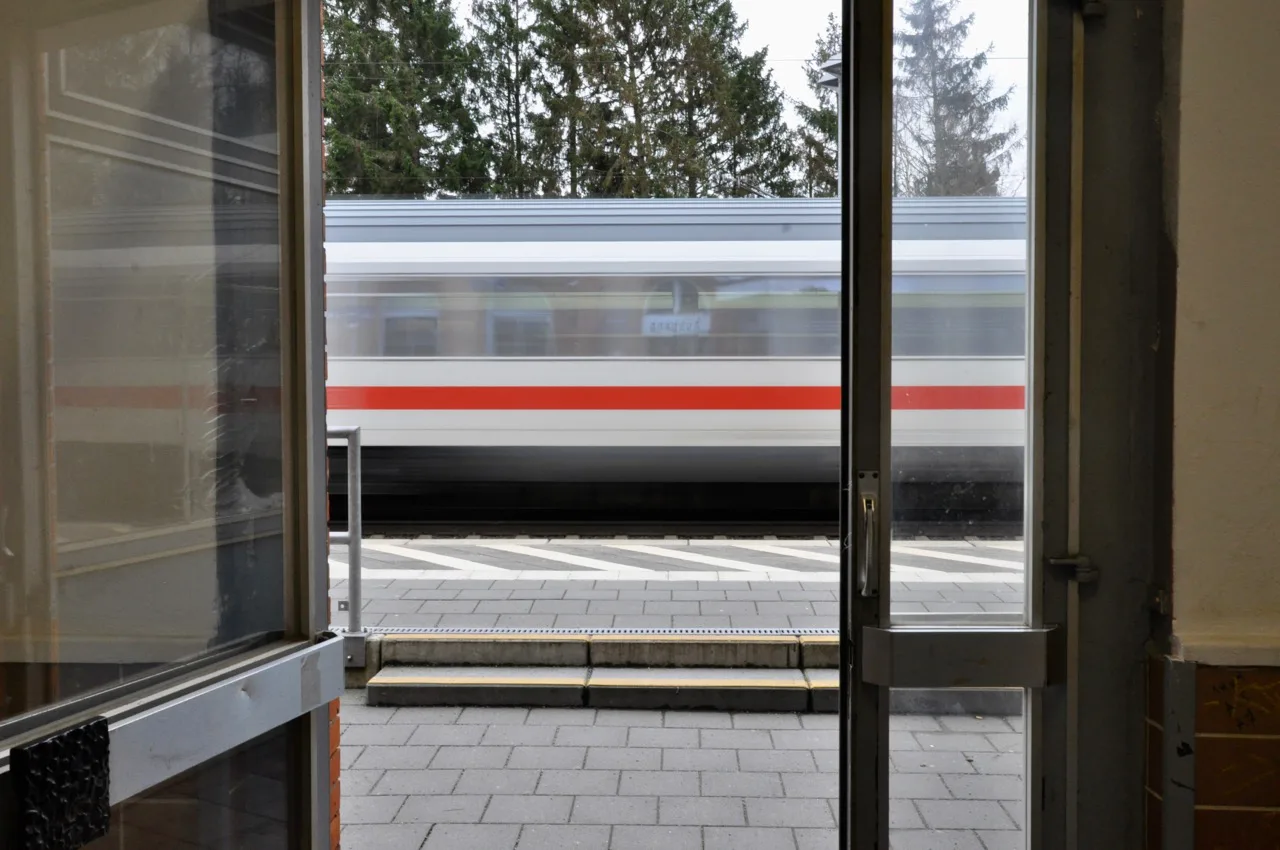 Blick durch eine Tuer auf einen vorbeifahrenden Zug